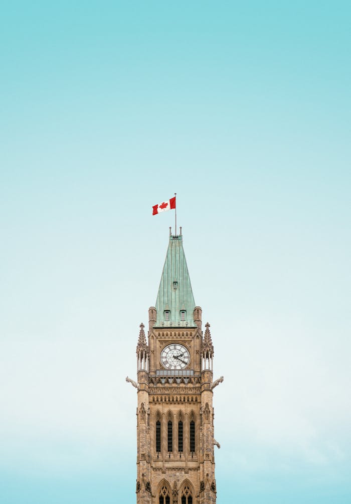 extra-programs-img The iconic Peace Tower in Ottawa, Canada, with a clear blue sky and Canadian flag.